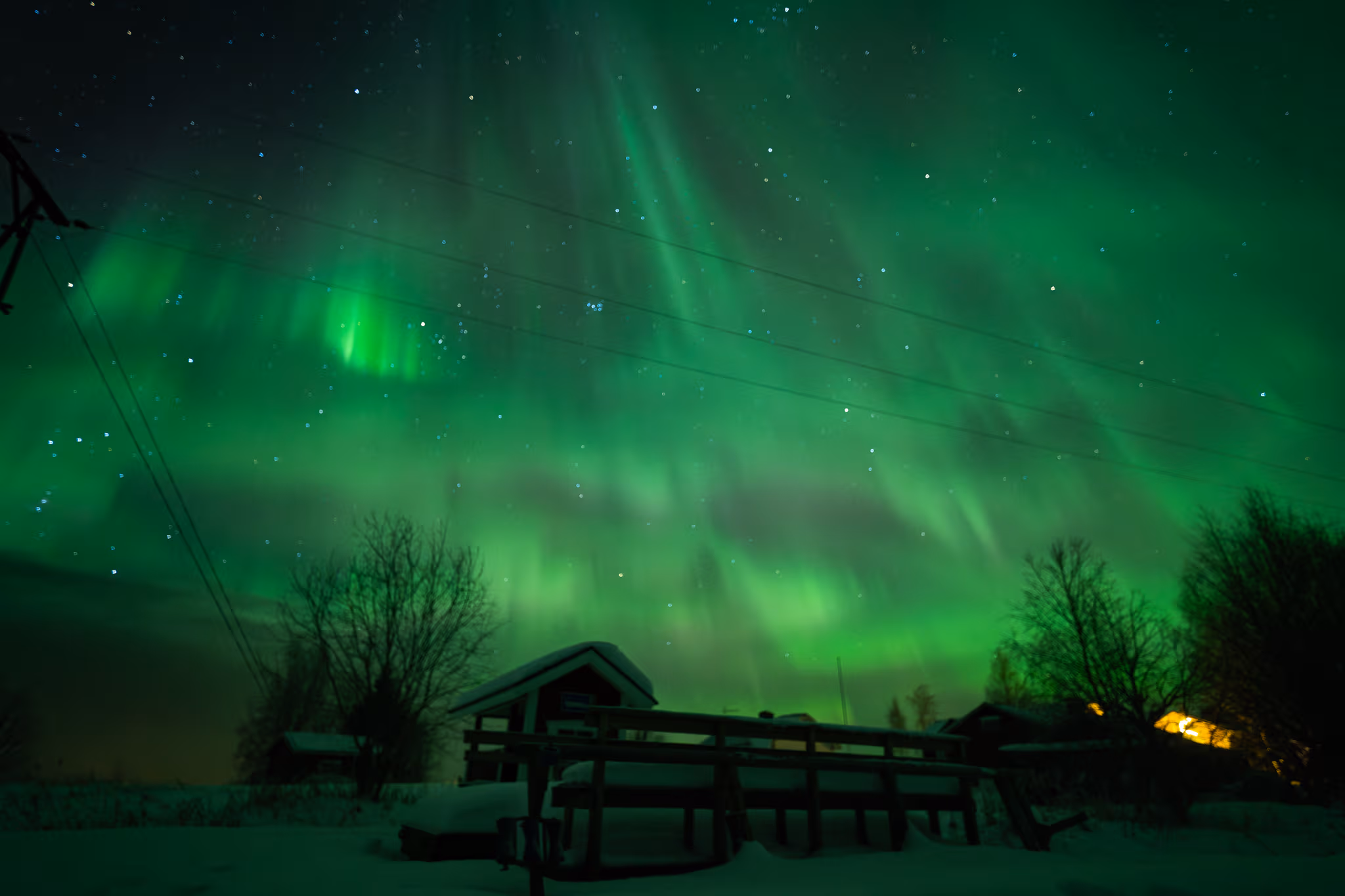 Northern lights over a snow-covered Lapland village in December