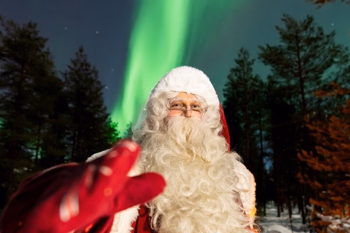 Santa in a snowy forest under the northern lights
